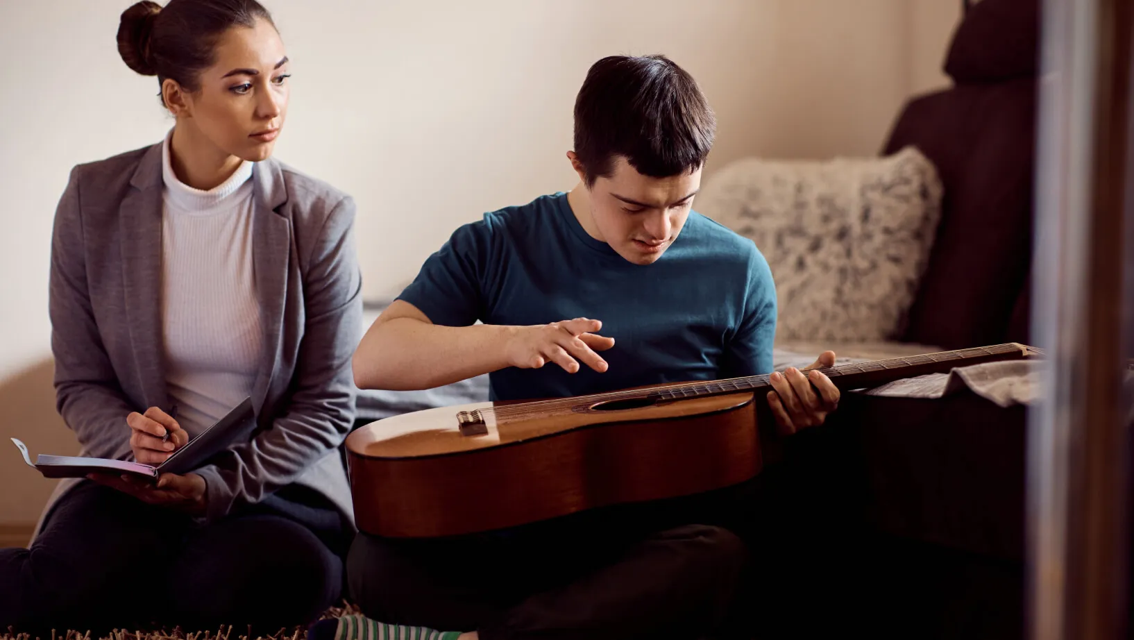 Un garçon pratiquant la guitare lors d'une séance de thérapie musicale.